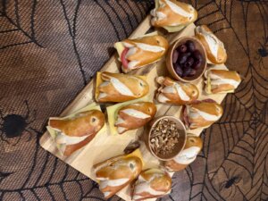 Belegte Laugenstangen mit Gespenstergesichtern auf einem Halloween-Buffet