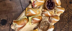 Halloween-Laugenstangen: Gespenster fürs Partybuffet Belegte Laugenstangen mit Gespenstergesichtern auf einem Halloween-Buffet
